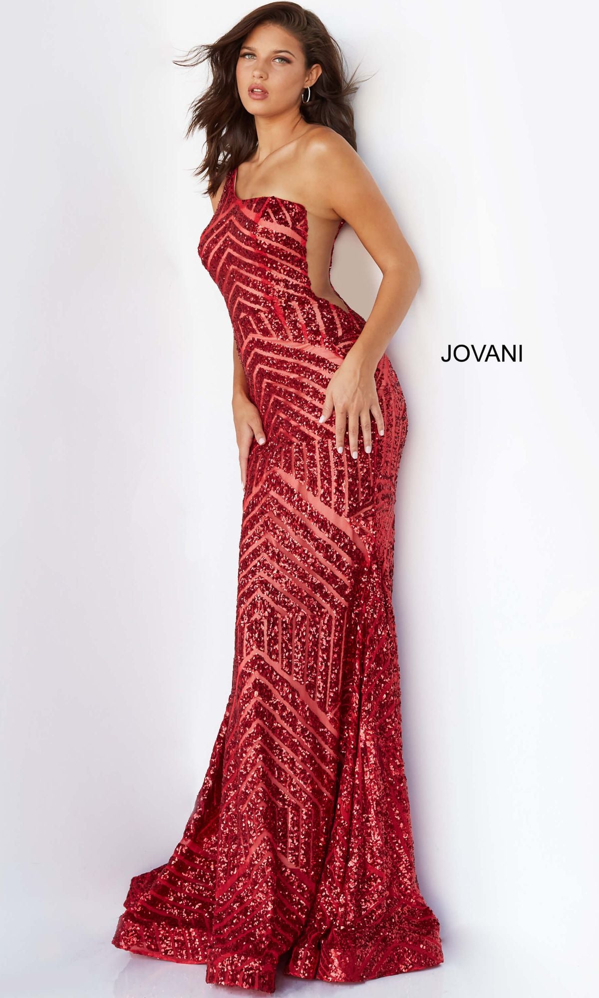 A woman models the One-Shoulder Jovani Sequin Prom Dress 06017 in red against a white background, with the